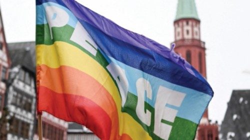 A rainbow colored flag with the inscription 'Peace' flutters in the wind during a demonstration ...