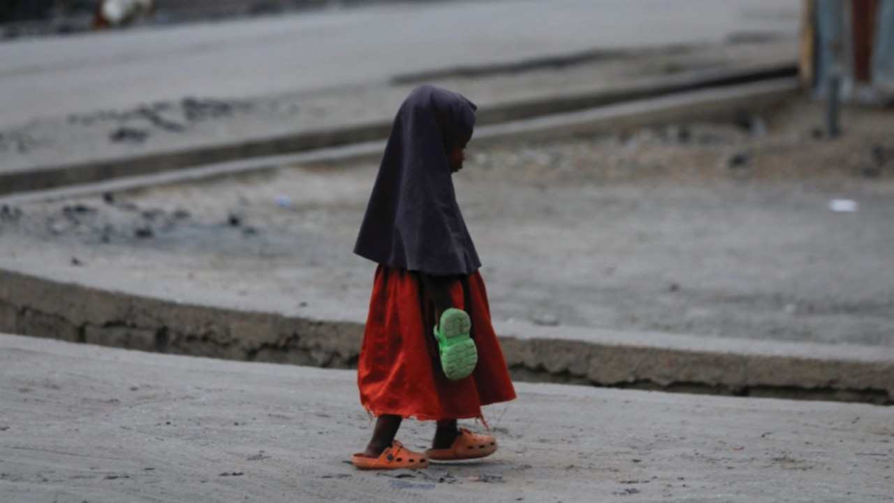 A girl carrying an extra pair of slippers, walks along the road in Maiduguri, Nigeria April 8, 2024. ...