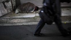 A homeless person sleeping in a street corner in Tokyo, Japan.