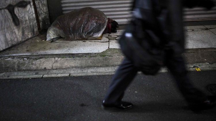 A homeless person sleeping in a street corner in Tokyo, Japan.