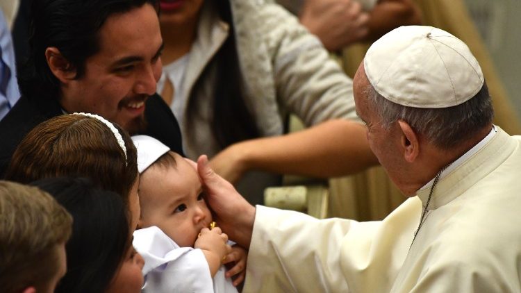 Pope Francis greets a family at a weekly General Audience