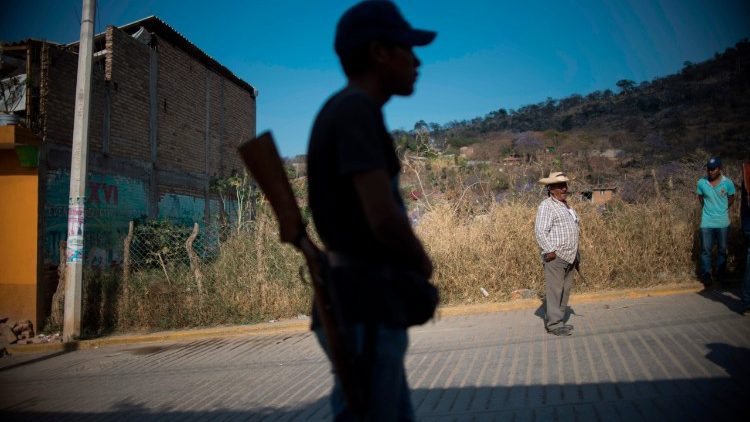 A Mexican community police member stands guard in an area where people have taken the fight against organized crime into their hands