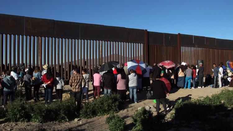In this file photo from February 2019, Bishops and priests pray with local residents near a section of the border fence along the U.S. - Mexico border 