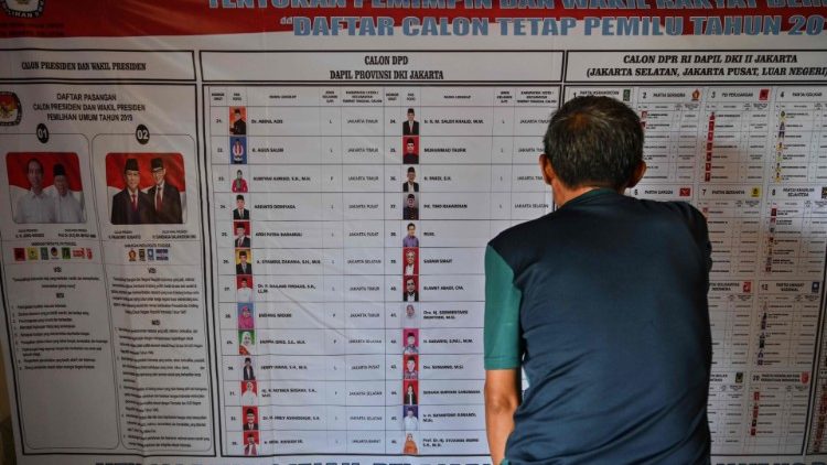Ein Indonesier studiert in Jakarta ein Wahlplakat