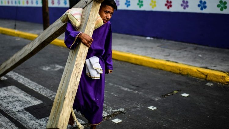 一位墨西哥年轻人在圣周五背十字架拜苦路