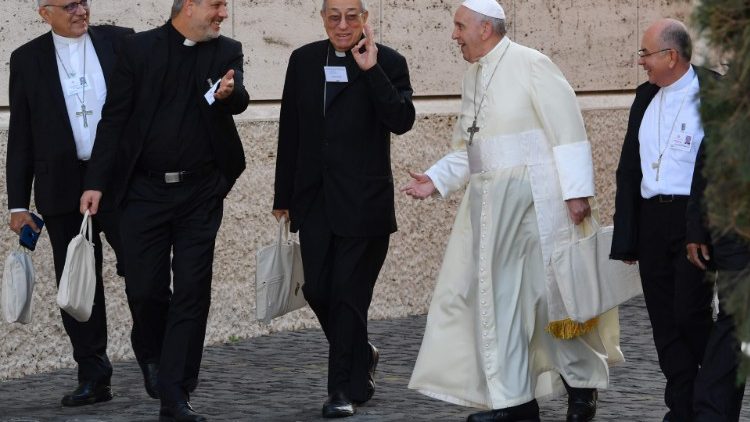 Pope Francis walks with other participants to the synod hall from the Papal Residence Santa Martha.