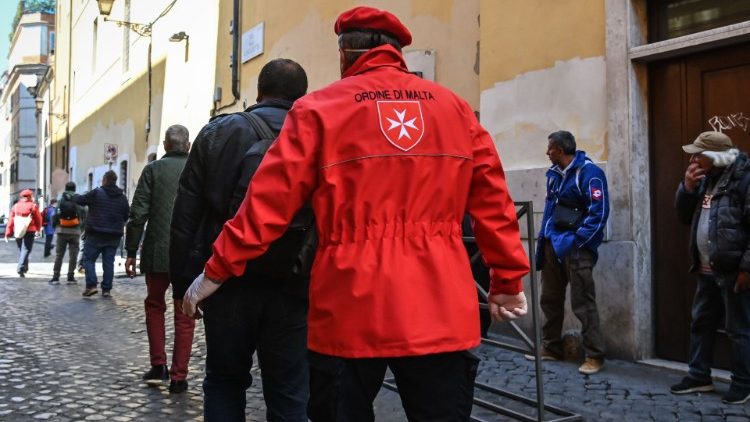 Volunteers from the Order of Malta distribute meals to the homeless in Rome