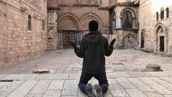 Un uomo in preghiera davanti alla Basilica del Santo Sepolcro
