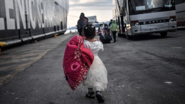 Menina prestes a embarcar em um ônibus com outros migrantes, próximo à Atenas