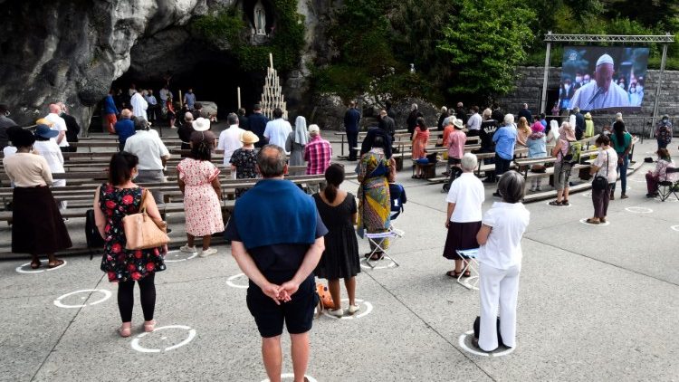 Fidèles réunis devant la Grotte de Lourdes pour suivre une retransmission du Pape, le 30 mai 2020. 