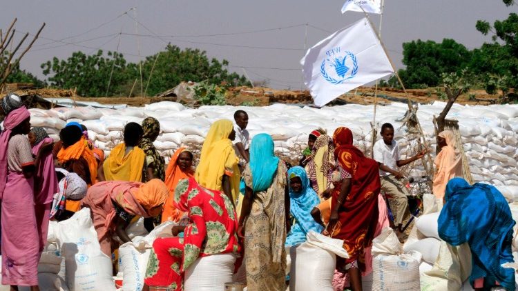 Displaced Sudanese women collect humanitarian aid in the Kalma camp for internally displaced people in Sudan's Darfur region.