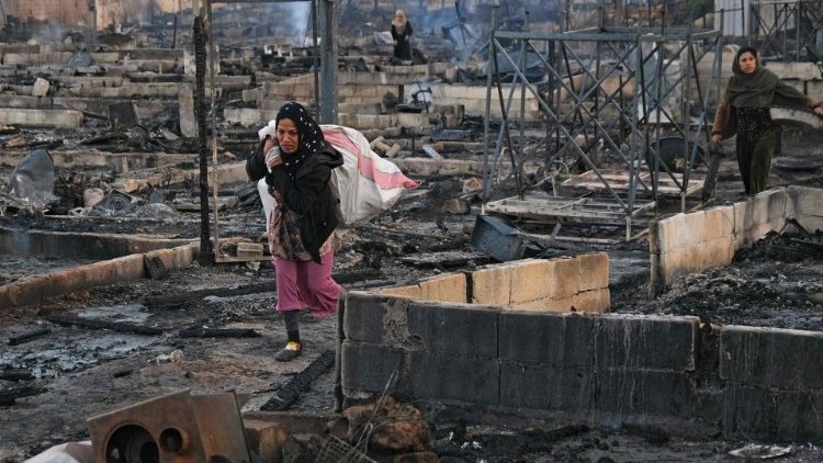 Syrian refugees salvage belongings from the wreckage of their shelters at a camp in Lebanon that was set on fire overnight.