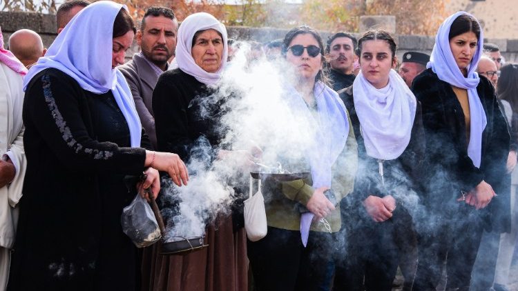 Des femmes yézidies brûlent de l'encens lors des funérailles de victimes de l'État islamique dans le village de Kojo, le 6 février 2021.