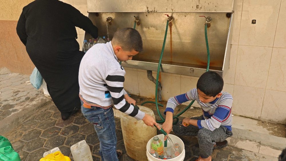 Niños recogiendo agua en la Franja de Gaza.