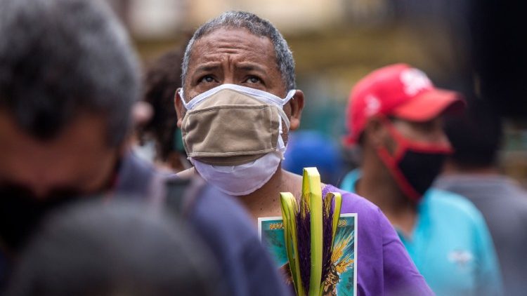 Fiel venezuelano protegido por máscara na celebração da Sexta-feira Santa