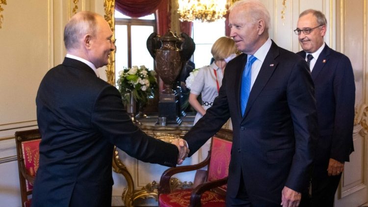 Joe Biden (R) shakes hands with Vladimir Putin (L)
