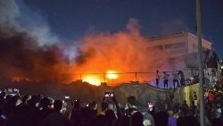 People take photos as flames engulf the coronavirus isolation ward of Al-Hussein hospital in Nasiriyah, Iraq