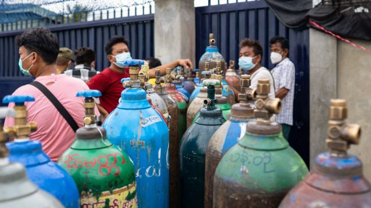 People wait in queue to fill up empty oxygen cylinders in Mandalay, Myanmar.