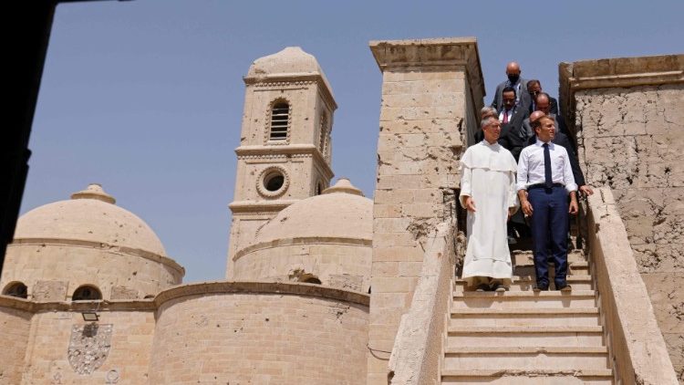 Le frère Poquillon aux côtés d'Emmanuel Macron visitant l'église Notre-Dame de l'Heure de Mossoul.