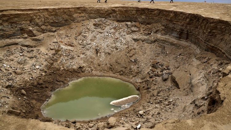 A sinkhole sits in a dried-up sea area to the south of the Dead Sea