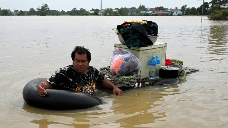 Un homme transporte ses biens après une inondation près de Phnom Penh, le 27 octobre 2021.