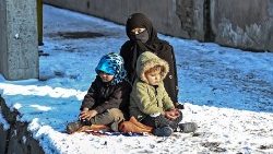 Una donna afghana con due bambini a Kabul (Mohd Rasfan/Afp)