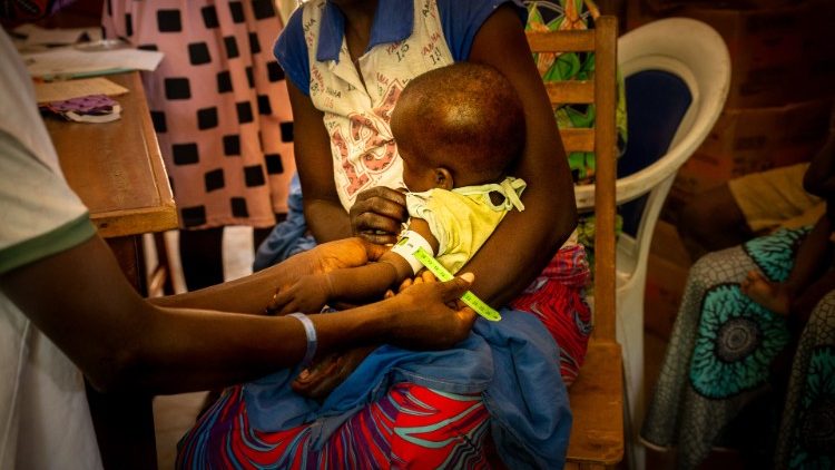 A health worker at a health center in the Central African Republic measures the circumference of a child's arm to see if the child is malnourished.