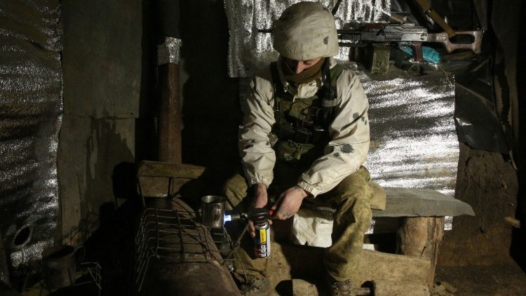 A Ukrainian serviceman sits in a dugout on the frontline with Russia-backed separatists in the Donetsk region