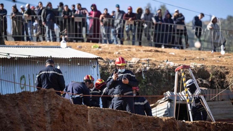 People look on as Moroccan emergency service teams attempt to rescue Rayan from a well.
