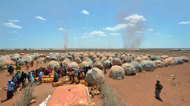 Families queue for water at a collection point in the outskirts of Baidoa, Somalia