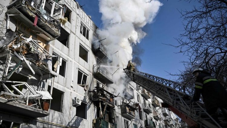 Firefighters work on a building after bombings of the eastern Ukraininan town of Chuguiv