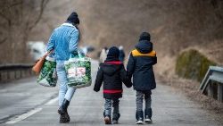 A woman and her two children walk toward the Slovak-Ukrainian border