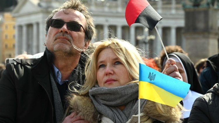 在聖伯多祿廣場上手持烏克蘭國旗參加三鐘經祈禱活動的人