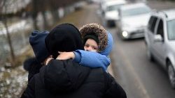 A child hugs his parents at Ukraine's border with Poland.