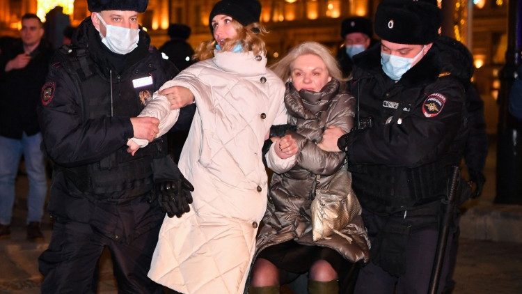 Russian police escort two women away from a protest in Moscow