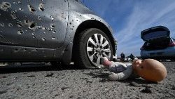 An abandoned doll lies next to a car riddled with bullets near Kyiv