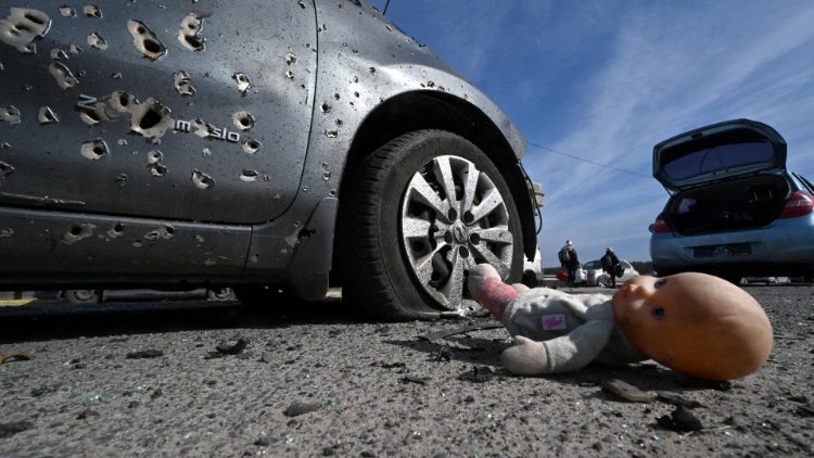 Một búp bê bị bỏ lại cạnh chiếc xe đầy vết đạn ở thành phố Irpin, Ucraina