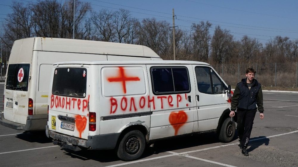 Um voluntário passa por seus veículos carregando e medicamentos para civis que estão presos em Mariupol em Zaporizhzhya, em 29 de março de 2022, em meio à invasão russa da Ucrânia. (Foto por Emre Caylak / AFP)
