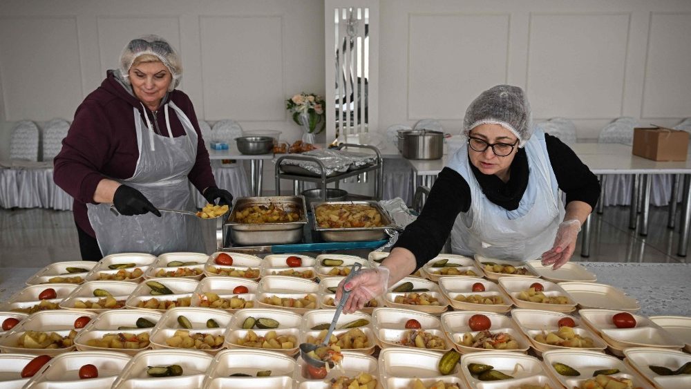 Voluntários preparam comida para refugiados ucranianos hospedados por residentes na vila de Sireti, 29 de março de 2022. - A Moldávia, uma pequena ex-república soviética de cerca de 2,6 milhões de pessoas entre a Ucrânia e a Romênia, viu cerca de 350.000 pessoas chegando desde o início da invasão russa . Cerca de 93.000 ficaram. (Foto de Daniel MIHAILESCU/AFP)