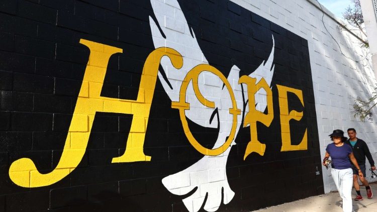 People walk past the 'HOPE' mural by artist Corie Mattie on March 30, 2022 in West Hollywood, California. The mural includes a QR code linking to a feminine hygiene product drive for Ukrainian refugees. According to data from the U.S. Census Bureau, California is home to around 112,000 residents of Ukrainian descent. Mario Tama/Getty Images/AFP 