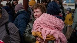 우크라이나와 폴란드의 국경에서 손녀를 품에 안고 있는 할머니