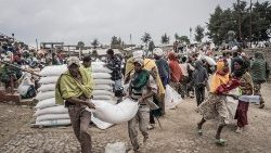 Homens carregam um saco de trigo durante uma distribuição de alimentos do Programa Mundial de Alimentos (PMA) para deslocados internos (IDP) em Debark, a 90 quilômetros da cidade de Gondar, na Etiópia. (Foto de Amanuel Sileshi/AFP)