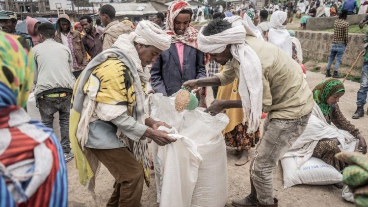 Displaced people from the war in Tigray receive bags of wheat