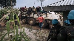 Freiwillige Helfer des Roten Kreuzes in der DR Kongo besteigen ein gepanzertes Fahrzeug (Archivbild)