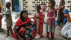 Medina Ahmed, deslocada de Konaba, senta-se ao lado de crianças em um complexo de prédios abandonados que abriga deslocados, perto da cidade de Dubti, a 10 quilômetros de Semera, na Etiópia. Mais de um milhão de pessoas precisam de ajuda alimentar na região de acordo com o Programa Alimentar Mundial. (Foto de EDUARDO SOTERAS/AFP)
