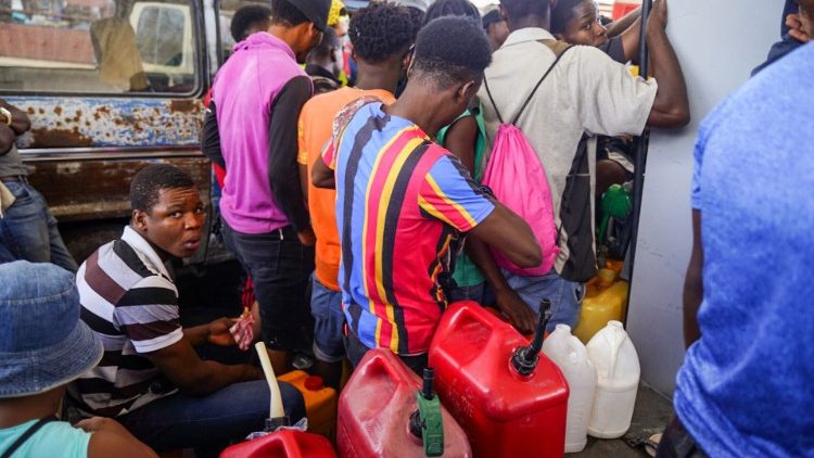 Haitians queue to collect petrol at a gas station in Port-au-Prince 