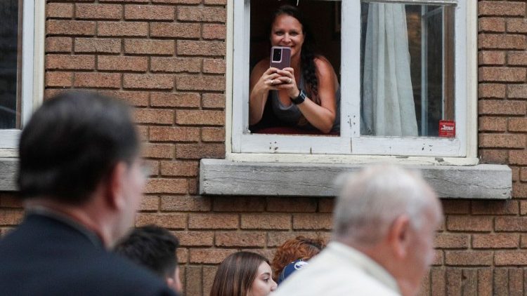 A woman records a video of Pope Francis in Quebec