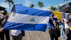 マナグアのカテドラルの敷地でニカラグア国旗を掲げる人々　2022年8月