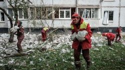 Ukrainare bär bort spillror efter bombardemang
