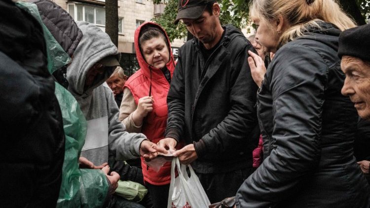 Um homem mostra sua carteira de identidade para receber alimentos durante sua distribuição para cerca de 3.000 pessoas pela filial local da Caritas Internationalis, uma organização de caridade católica, em Kharkiv, em 27 de setembro de 2022. (Foto de Yasuyoshi CHIBA / AFP)